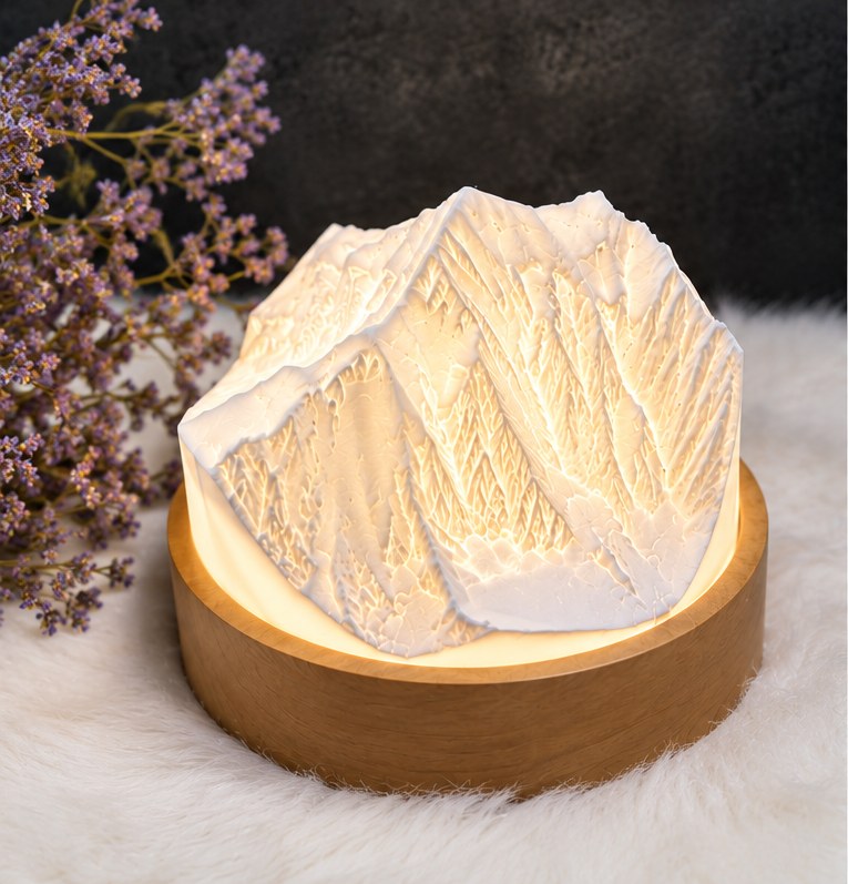 Mountain lamp lit up: the summit relief resting on its pear-wood base